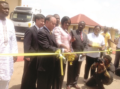 Mrs Dzifa Attivor (2nd left) being supported by Mr Gao Wenzhi to cut the tape for the launch of the A7 Sinotruk trucks.